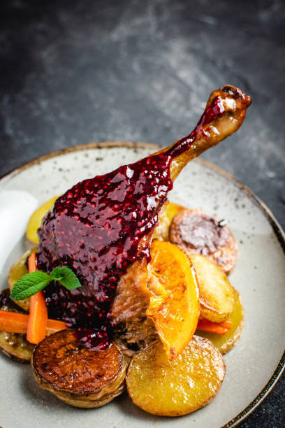 istock Roasted Goose Leg with Potatoes, Carrots and Oranges 1157354956