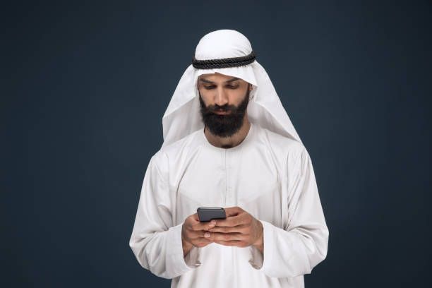 istock Arabian saudi man on dark blue studio background 1157355324