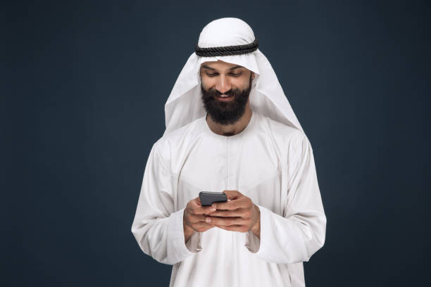 istock Arabian saudi man on dark blue studio background 1157355329