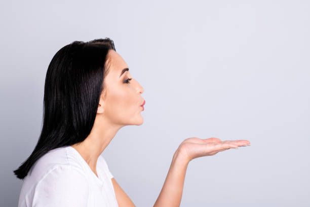 Close up side profile photo beautiful amazing she her lady perfect ideal, appearance send air kisses boyfriend husband overjoyed arm raised wear casual white t-shirt isolated bright grey background