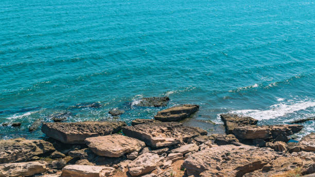 istock Sea coast with rocky shore and small waves 1157358412