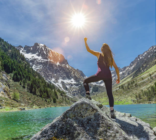 istock Happy Woman in victory pose on a rock 1157364150