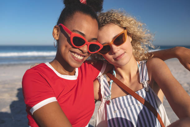 istock Female friends relaxing together on the beach 1157365913