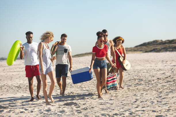 istock Group of friends walking together on the beach 1157366068