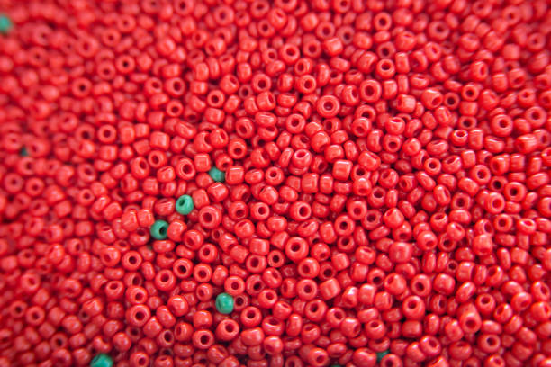 beaucoup de perles en plastique fusibles colorées utilisées pour les arts et l'artisanat. décoration pour le papier peint de bureau, affiche, livret de couverture, carte. - bead bugle necklace red photos et images de collection