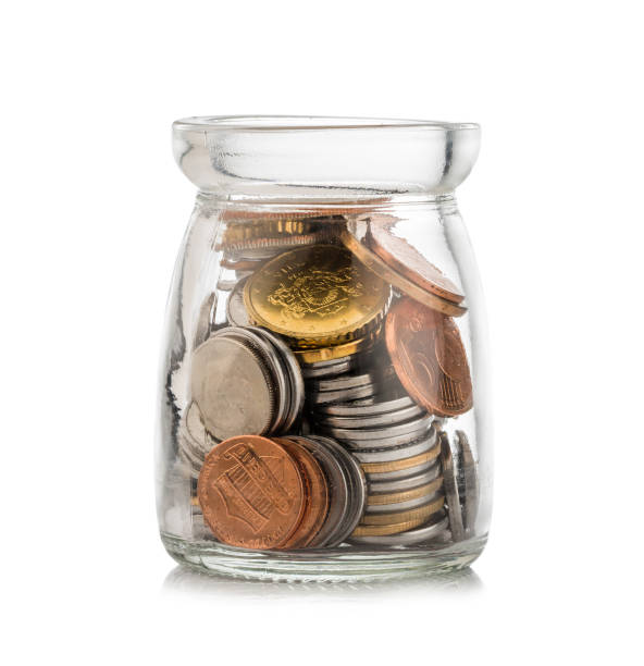 istock Coins in savings jar on white background 1157369425