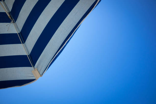 Striped blue and white sunshade over blue sky
