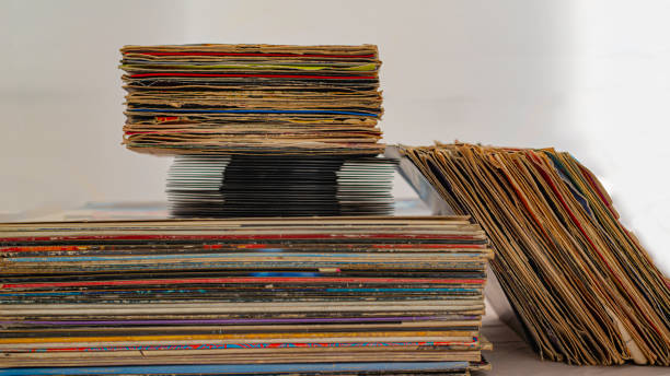 istock stack of 45 and 33 rpm vinyl records arranged in a vertical stack. The discs have covers used in poor condition for wear 1157371857