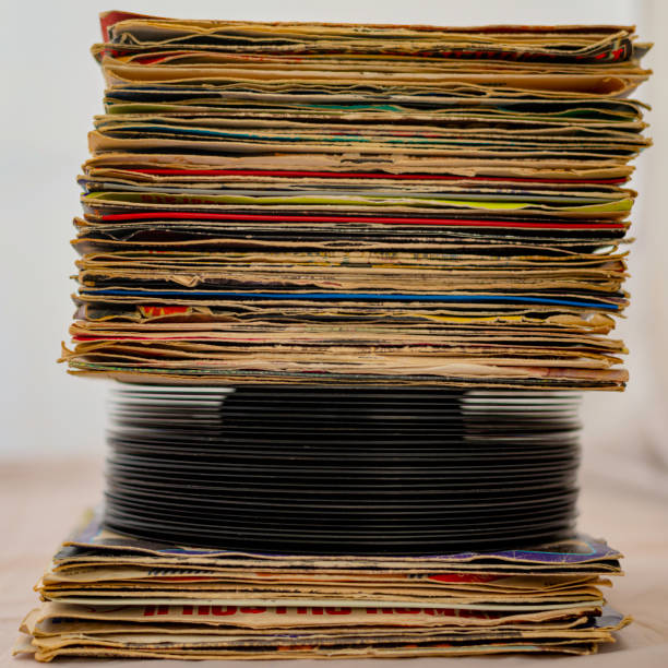 istock stack of 45 rpm vinyl records arranged in a vertical stack. The discs have covers used in poor condition for wear 1157371860