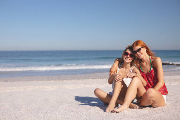 istock Female friends relaxing together on the beach 1157374094