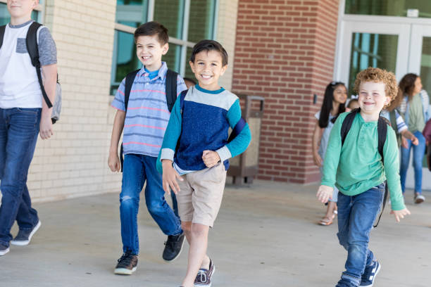 istock Schoolboy smiles at the camera while leaving school 1157374879