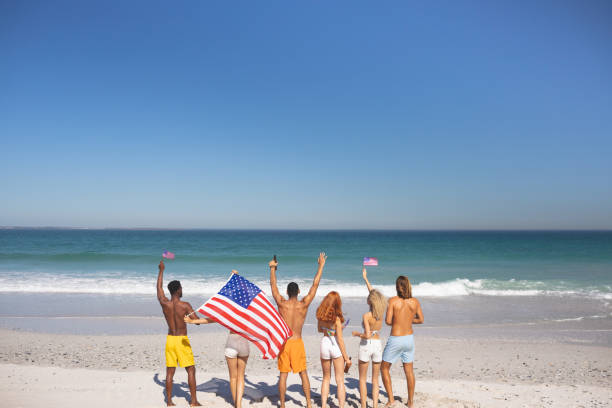 istock Group of friends raising their hands on the beach 1157376548