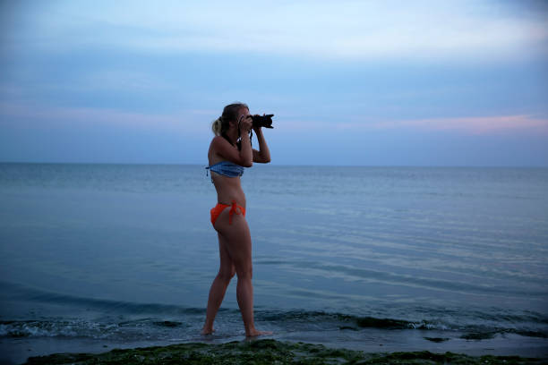 istock Woman on the sea coast on sunset 1157377728