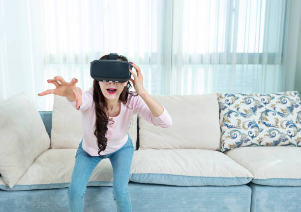 istock Woman wearing virtual reality simulator at home 1157378088