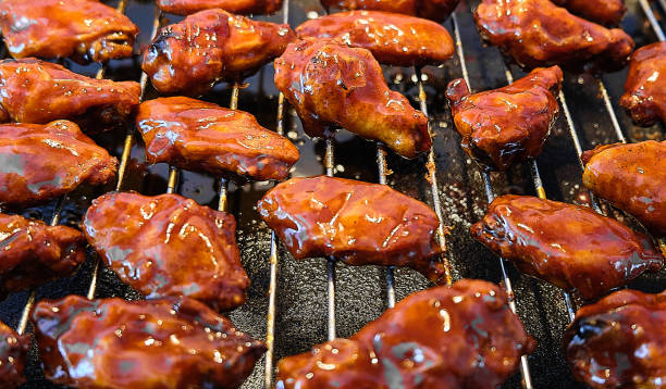 istock Marinated BBQ Chicken Wings on a baking grate, close-up. 1157380679