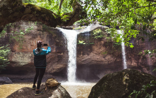 istock Women tourists Is shooting a waterfall She came to walk alone. 1157381977
