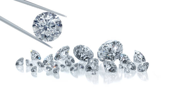 istock Group of diamonds with single diamond in tweezers 1157383706