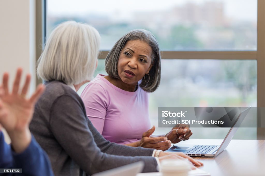 Mature women express concerns about learning computer programming During a break in the adult ed computer programming class, two mature women express their concerns to each other. African-American Ethnicity Stock Photo