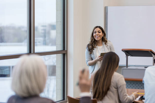 istock Teacher takes question from class member about digital tablets 1157387225