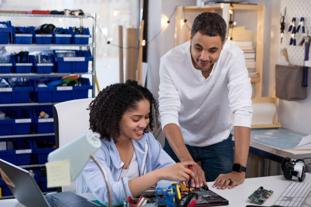 istock Dad comes into workshop as daughter takes apart computer 1157387433