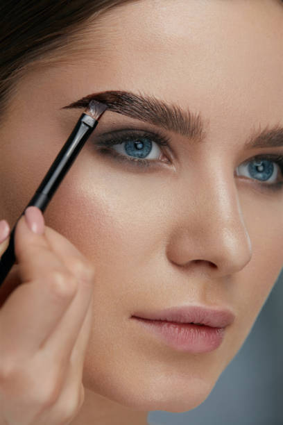 istock Eyebrow coloring. Woman applying brow tint with makeup brush 1157390025