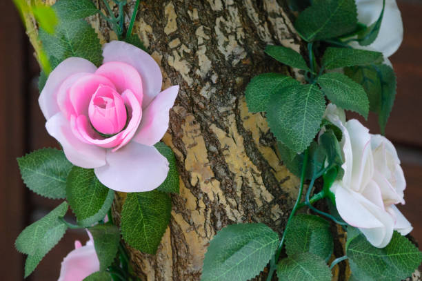 istock Decorating of artificial flowers with a tree trunk. Close-up. 1157390782