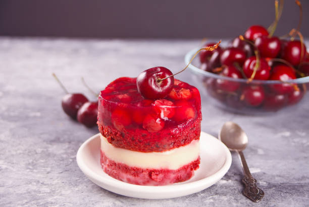 Homemade cherry cake with vanilla cream and cherry jelly on the gray background stock photo