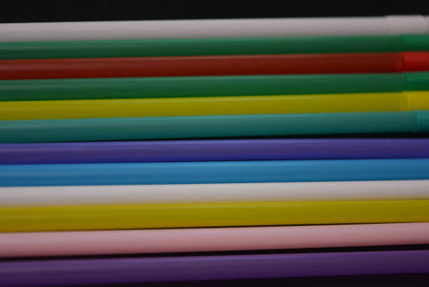 istock Multi-colored plastic stickers, tubes laid out in a graphic and rainbow format.  Tubules were used to decorate glasses and cocktails for parties and events.  Interesting light background and image. 1157392286