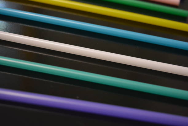 istock Multi-colored plastic stickers, tubes laid out in a graphic and rainbow format.  Tubules were used to decorate glasses and cocktails for parties and events.  Interesting light background and image. 1157392620