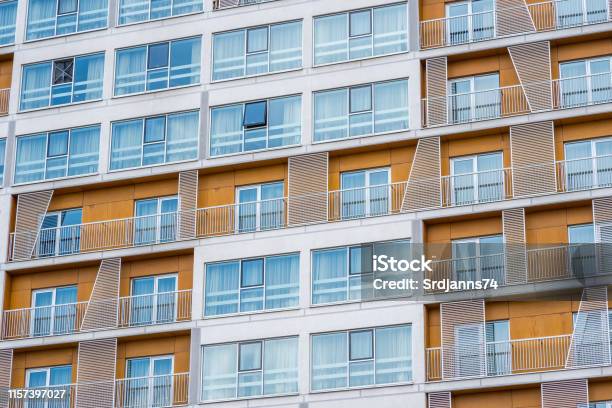 Arquitectura Genérica Moderna En Nuevo Edificio Residencial Con Ventanas Y Paredes Exteriores Naranjas Mezcladas Con Mármol Y Metal Foto de stock y más banco de imágenes de Abstracto