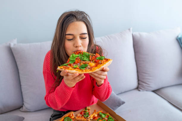 istock Girl eating a delicious pizza 1157400090