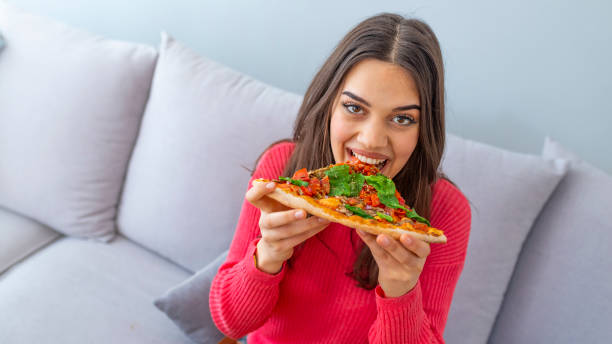 istock Girl eating a delicious pizza 1157400152