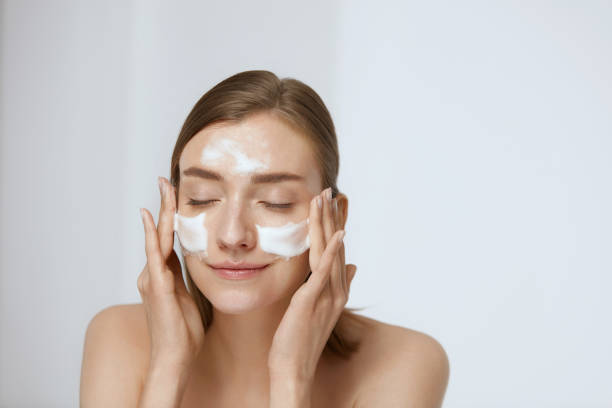 face skin care. woman applying facial cleanser on face closeup - facial cleanser imagens e fotografias de stock