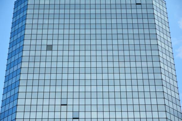 istock Clouds reflected in windows of modern office building 1157412555