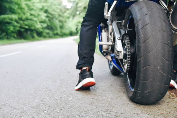 istock Man starting riding on motorcycle from roadside 1157414124