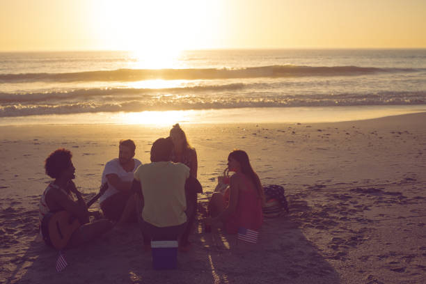 istock Group of friends having fun at beach during sunset 1157414958