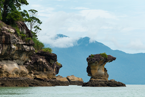 Sea stacks along the coastline of Bako National Park. Beautiful rock formations is against mountain and sky.