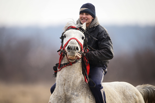 Pietrosani, Romania - January 6, 2019: Man is bareback riding an adorned horse before an Epiphany celebration horse race.