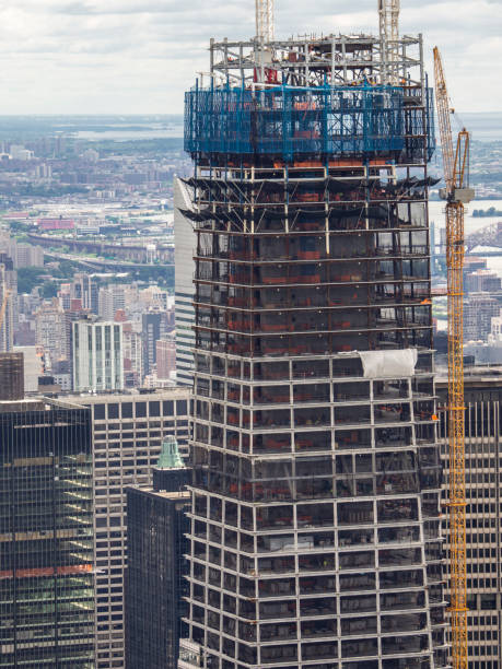 istock New York, NY, USA. New skyscrapers under construction. Construction site with cranes, elevators and scaffolding 1157425908