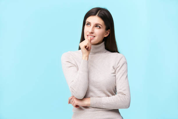 istock young caucasian woman looking up thinking 1157426937