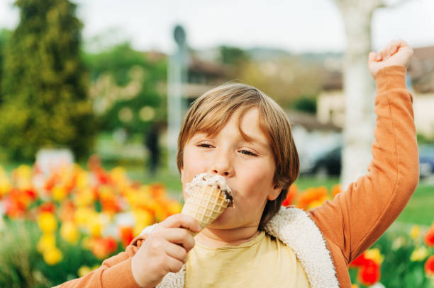istock Happy kid boy eating stracciatella ice cream in spring park 1157428252