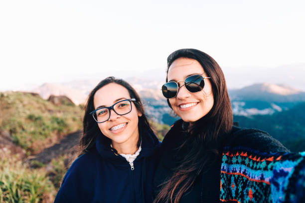 Two young women taking a selfie outdoors at Serra dos Orgaos National Park Two young women taking a selfie outdoors at Serra dos Orgaos National Park glengarry cap stock pictures, royalty-free photos & images