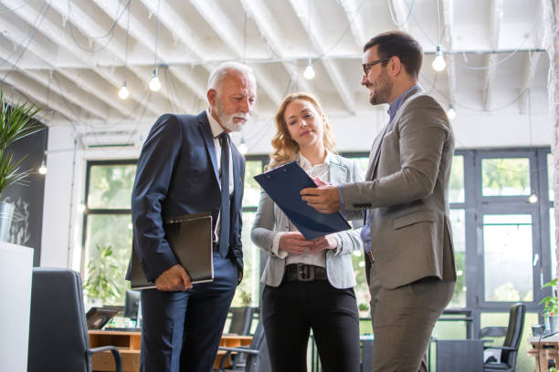 istock Successful businessteam of three standing in office and planning work 1157433819