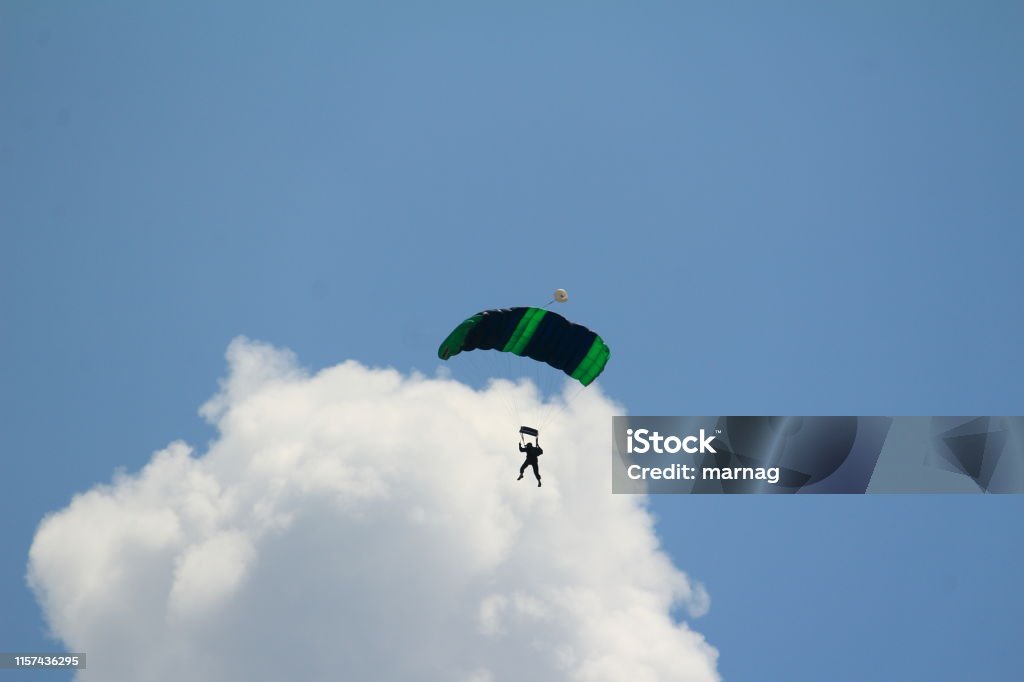 in the air a paraglider in front of the clouds Adult Stock Photo