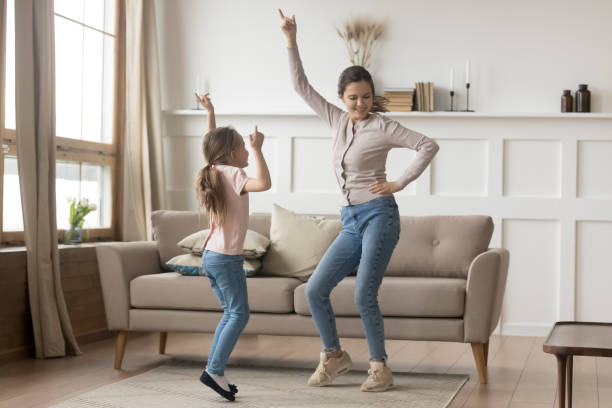 istock Active mother dancing at home with little daughter 1157439220