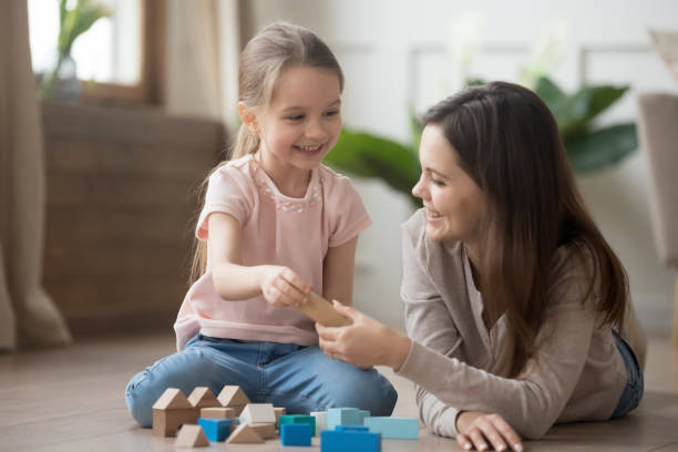 madre o babysitter giocano con il bambino con blocchi giocattolo - people joy relaxation concentration foto e immagini stock