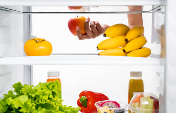 istock Slender lady choosing apple in refrigerator shelf 1157441126