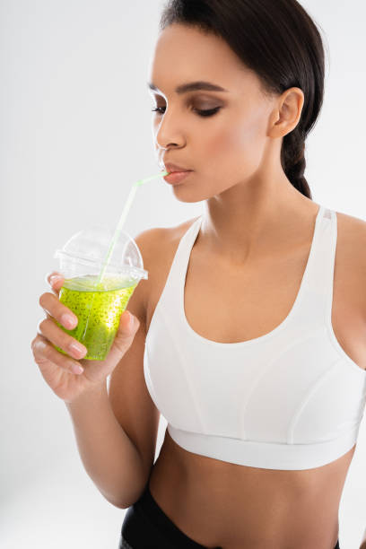 istock Young slender lady drinking fresh juice cocktail 1157441145