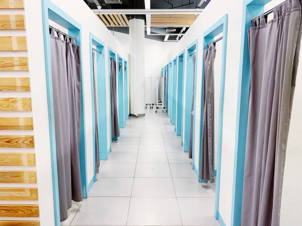 istock Empty fitting rooms with grey curtains and white walls 1157441469
