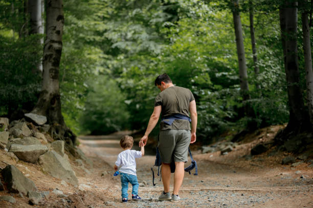 istock father and son walking along a path in the forest 1157443889
